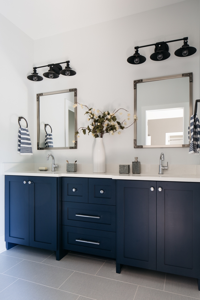 Jack and Jill bathroom with dark lights, white countertop, and navy vanity.