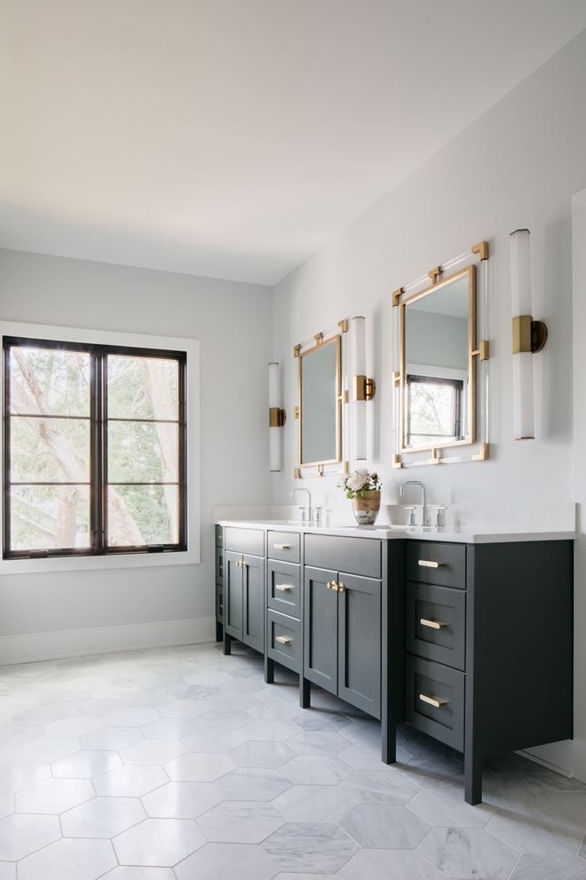 Master bathroom with long dark vanity and statement mirrors and bar sconces and geometric tiling