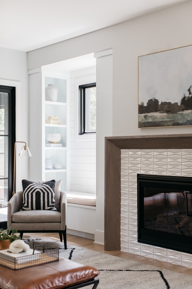 Closeup of fireplace, chair, and bench seat with bookshelf