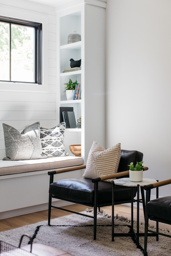 Bench seat with shelves and a black leather armchair