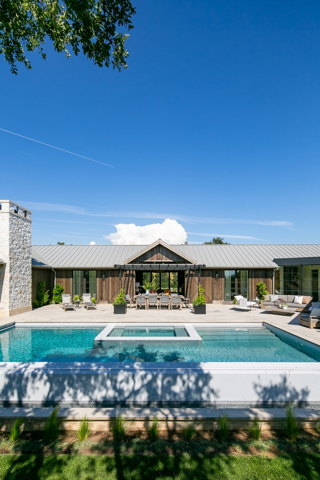 california farmhouse rear view with infinity style pool.