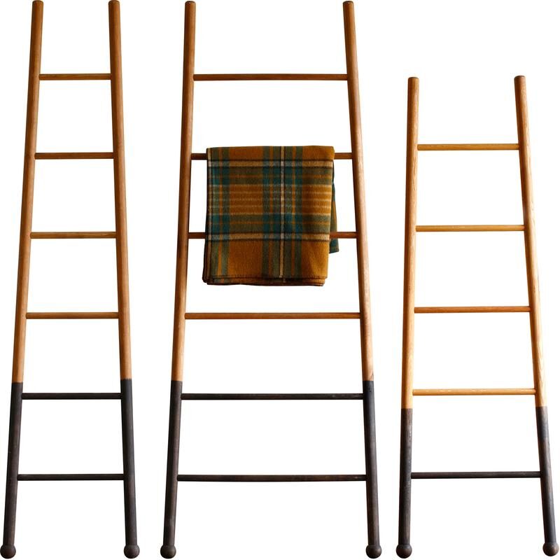set of three tapered ladders with a decorative blanket