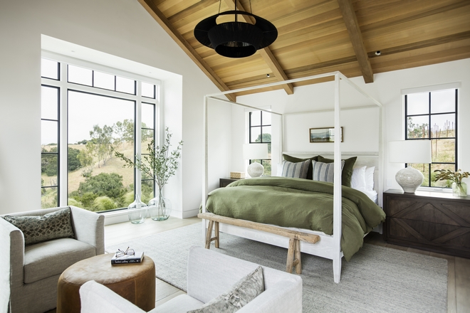 master bedroom with white bed frame and large windows