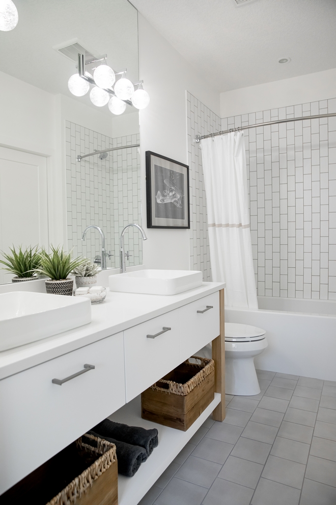 white themed bathroom with white shower tile and double sinks