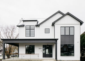 white home with black accents and wrap around porch