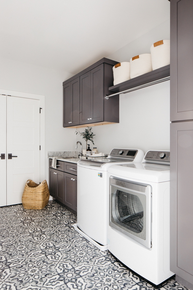 laundry room with double doors, washer and dryer, sink, and dark cupboards