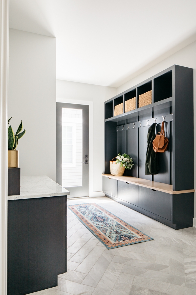Mudroom with runner and custom dark wood  hutch with hooks, bins, baskets, and a bench seat.
