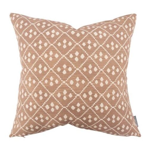 faded orange/pink pillow with large and small diamond patterns on it in cream color