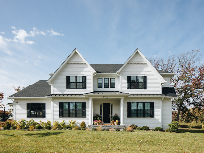symmetric white southern style home with columned front porch and black windows