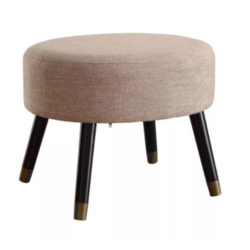 Round beige ottoman stool with four dark wooden legs